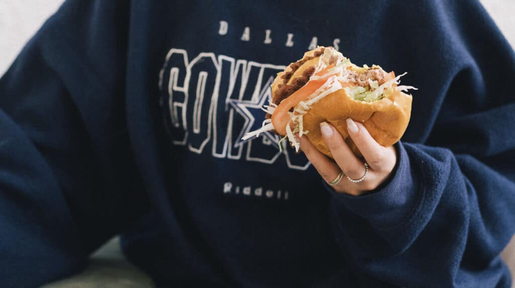 Persona amb una hamburguesa a la mà